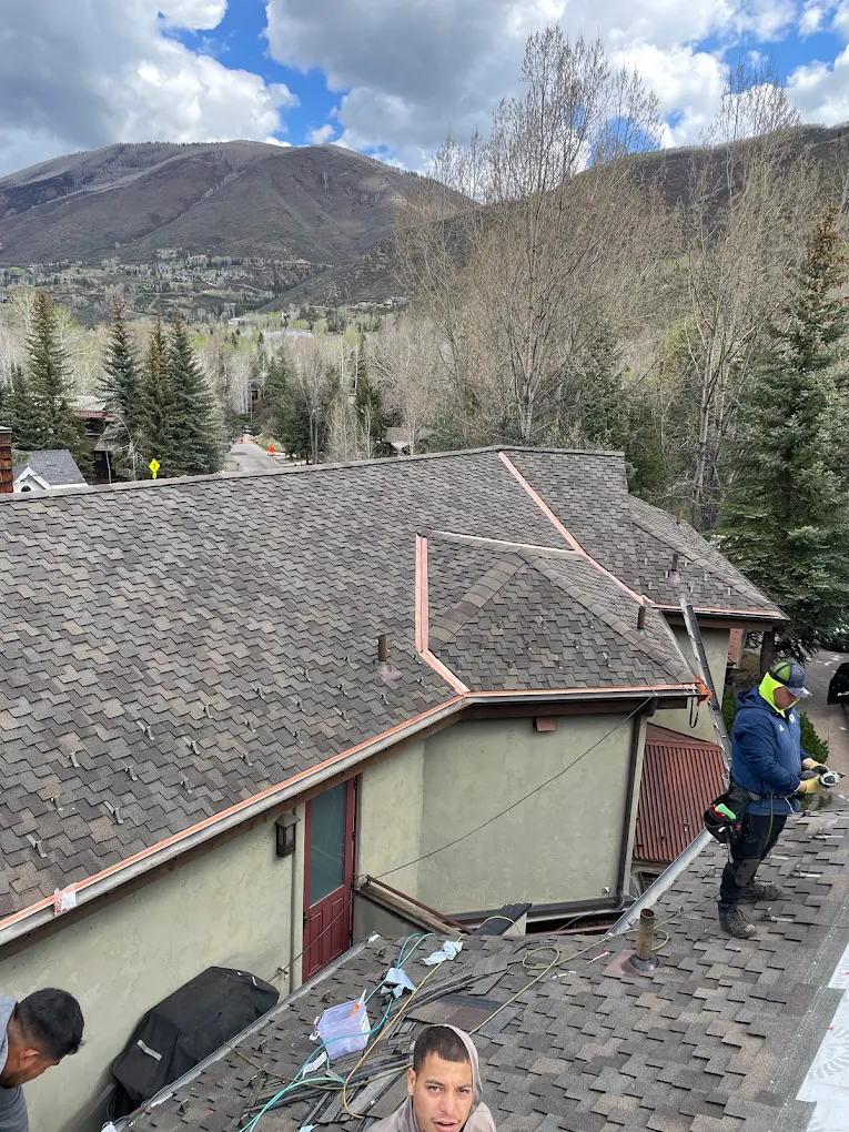 Roof work around copper valley flashing on an Aspen home