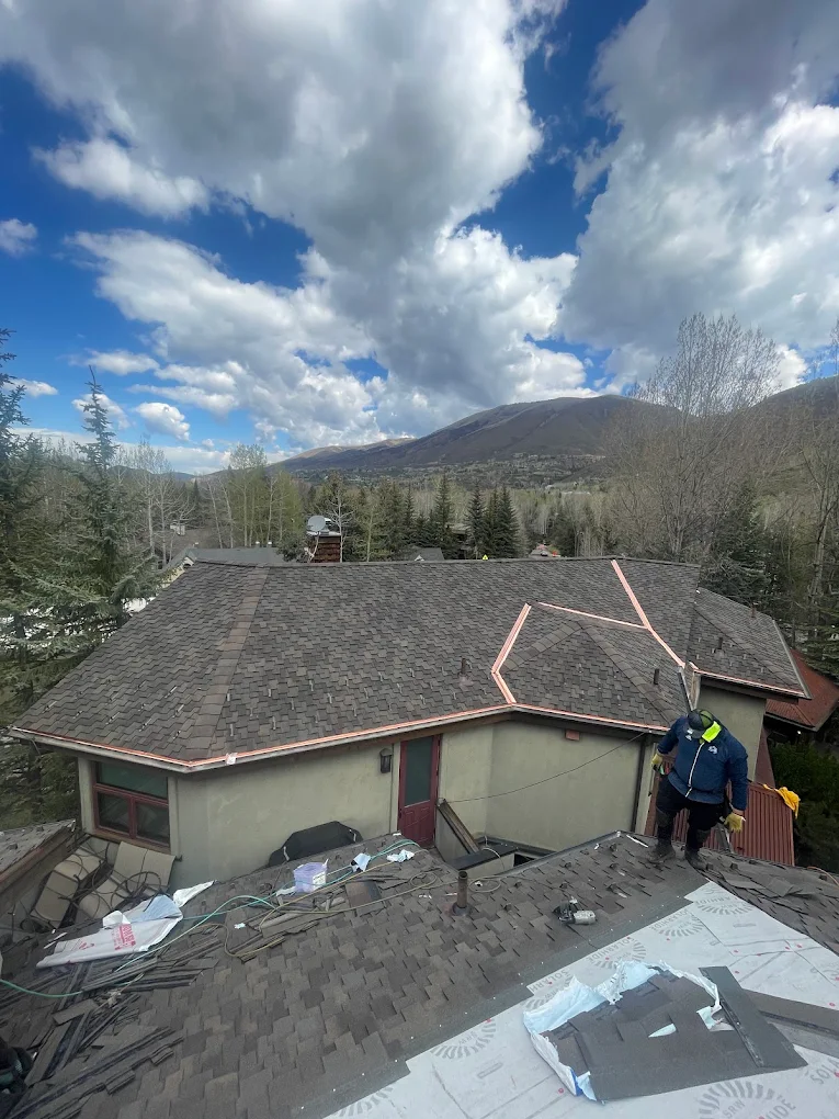 NorthStar Roofing crew installing an asphalt shingle re-roof with copper flashing on an Aspen, Colorado home