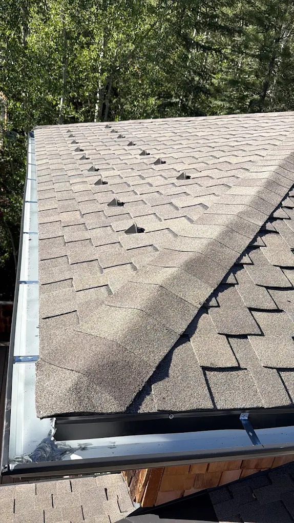 Seamless gutter and snow guards on an asphalt shingle roof