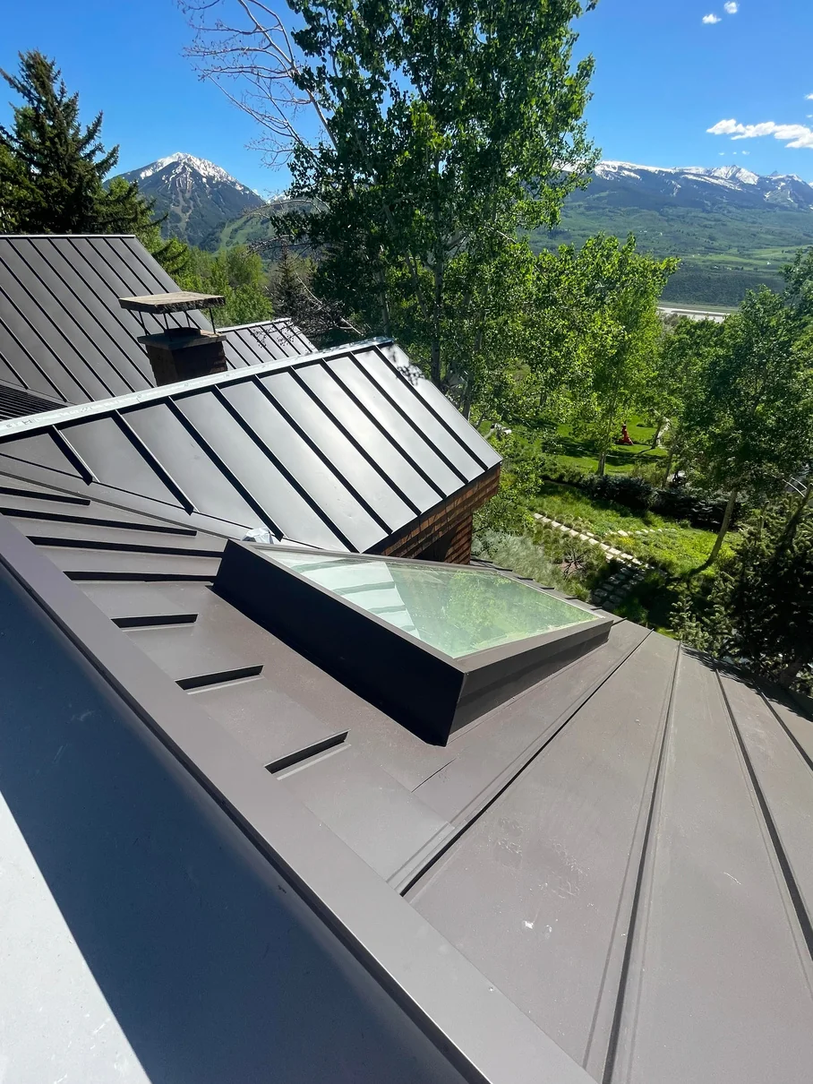 Completed standing seam metal roof on Danielson Drive in Aspen with flush skylight and mountain views