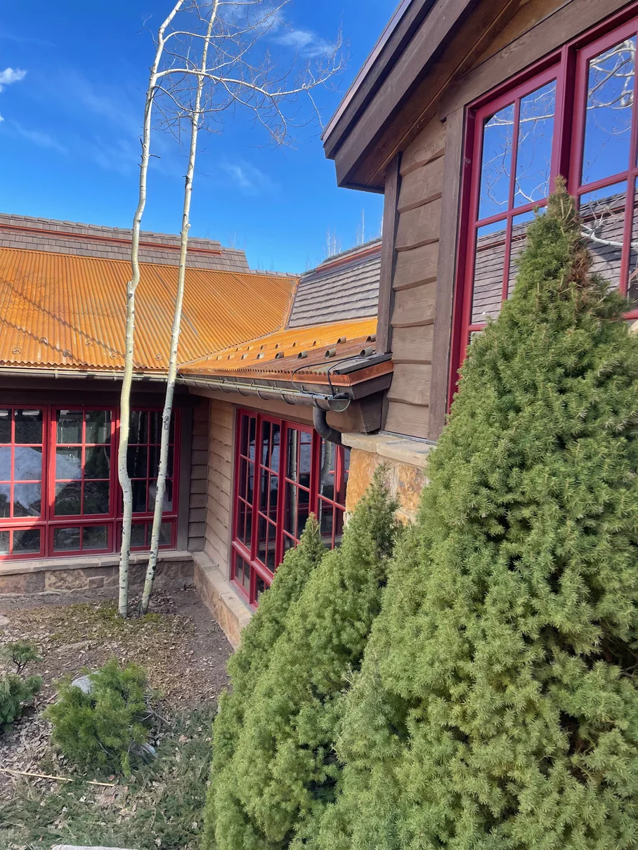 Moore Drive Aspen home with Brava synthetic shake and weathered corrugated Corten steel roof sections and snow guards
